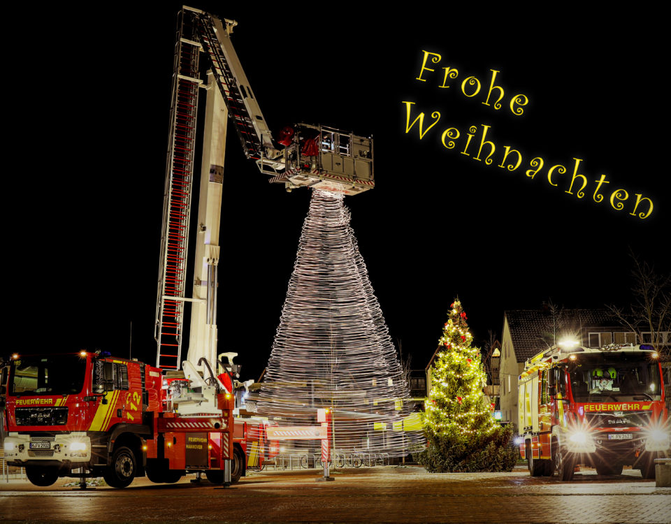 Bild mit der Botschaft „Frohe Weihnachten“. Zu sehen sind zwei Feuerwehrfahrzeuge der Ortsfeuerwehr Misburg an der Endhaltestelle der Linie 7 in Misburg. Die Teleskopmastbühne ist aufgebaut und an ihrem Korb hängt ein Lichter-Weihnachtsbaum.